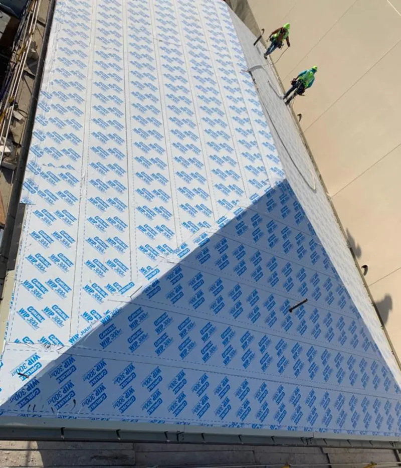 Professional roofers installing underlayment on a metal roof in Perkiomen